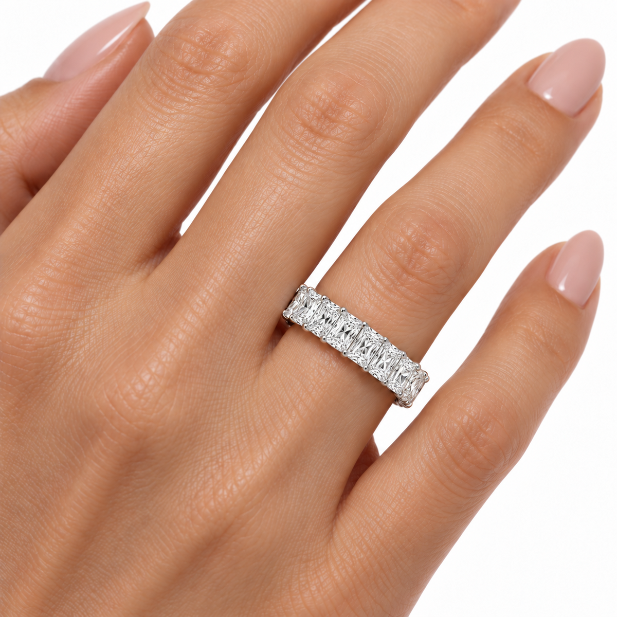 4.00 CTW radiant-cut lab-grown diamond eternity band in 14K white gold worn on a woman’s ring finger, studio close-up.