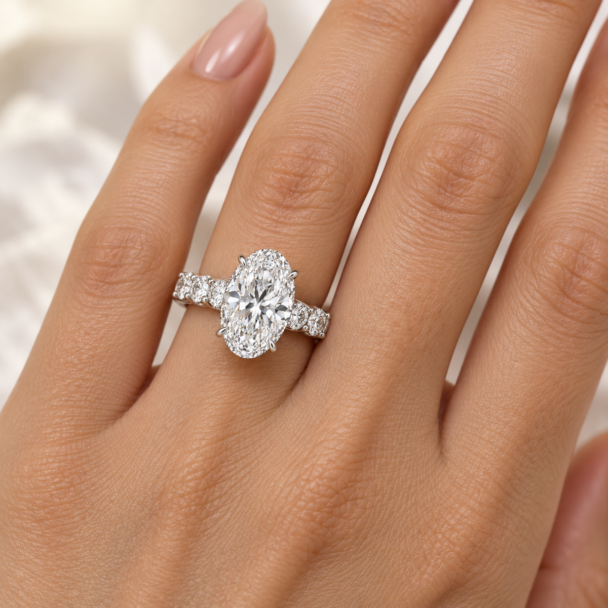 4.50-carat oval lab-grown diamond hidden halo engagement ring with round diamond side stones, shown worn on a hand.

