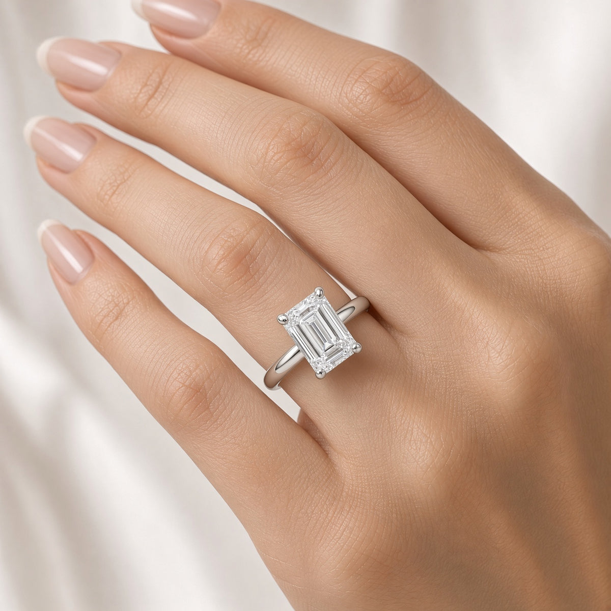 Emerald cut lab-grown diamond hidden halo engagement ring worn on hand