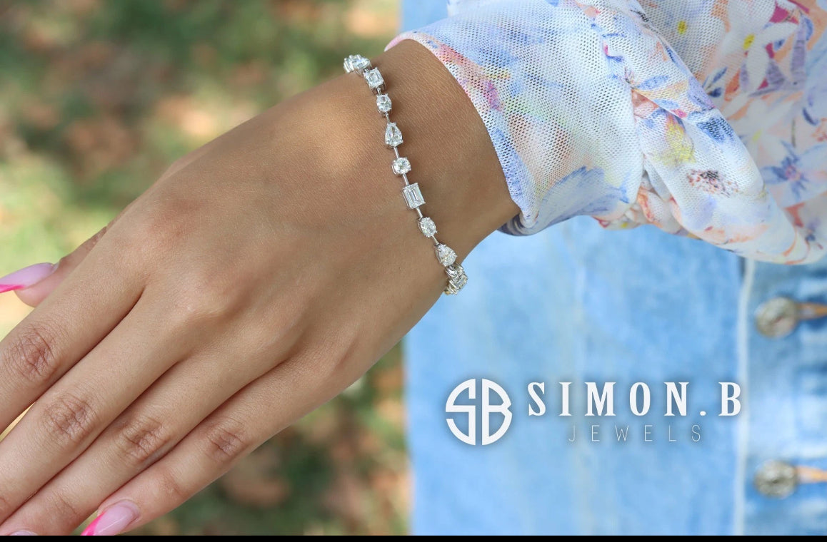 Hand wearing a diamond bracelet with 'Simon B' branding.